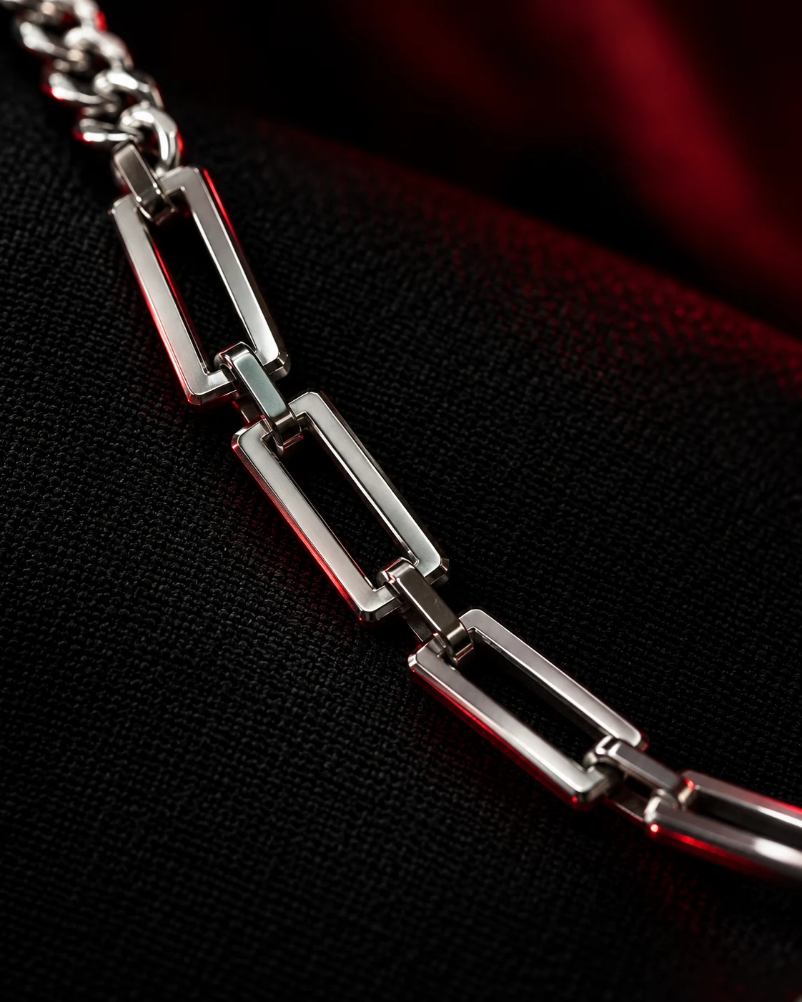 A fragment of silver catching red light in the dark